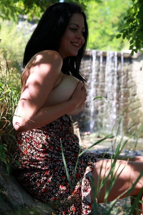 Young brunette Shione Cooper highlights her large tits while getting naked