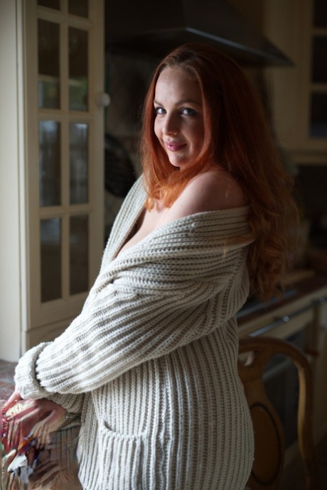 UK redhead Kara Carter rubs cream into her big natural tits in the kitchen
