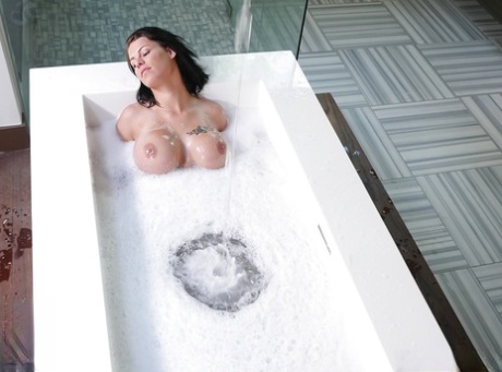 Busty brunette MILF Peta Jensen wetting naked body in bathtub