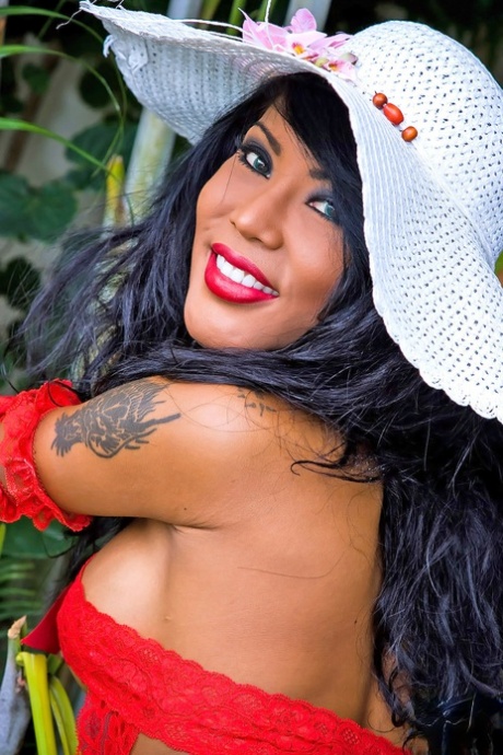 Kinky tranny Areeya exposes her big tits & poses in hot red fishnets outdoors