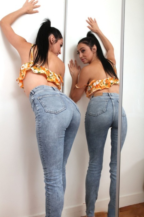 Hot amateur brunette with a ponytail Rhia reveals her big tits and poses