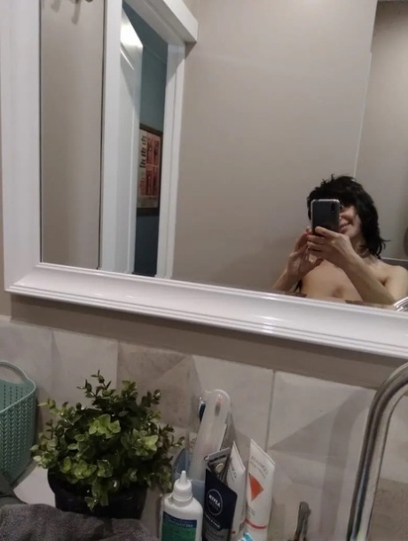 Mature brunette takes nude selfies in the bathroom showing her saggy tits