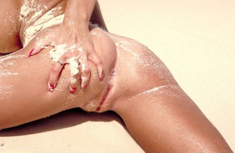 Canadian bombshell with giant breasts Tiffany Towers strips on the sandy beach