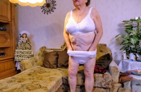 Granny with red lipstick Bagra undresses and displays her big saggy tits